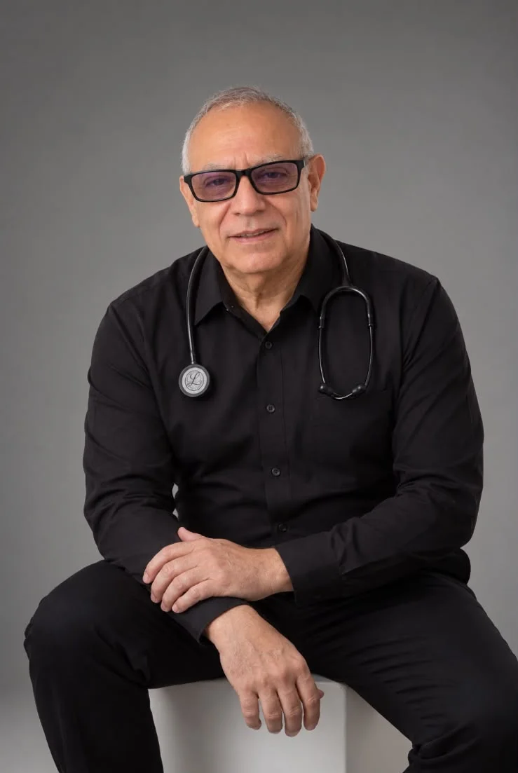 Retrato del Dr. Heriberto Arras con camisa negra y estetoscopio